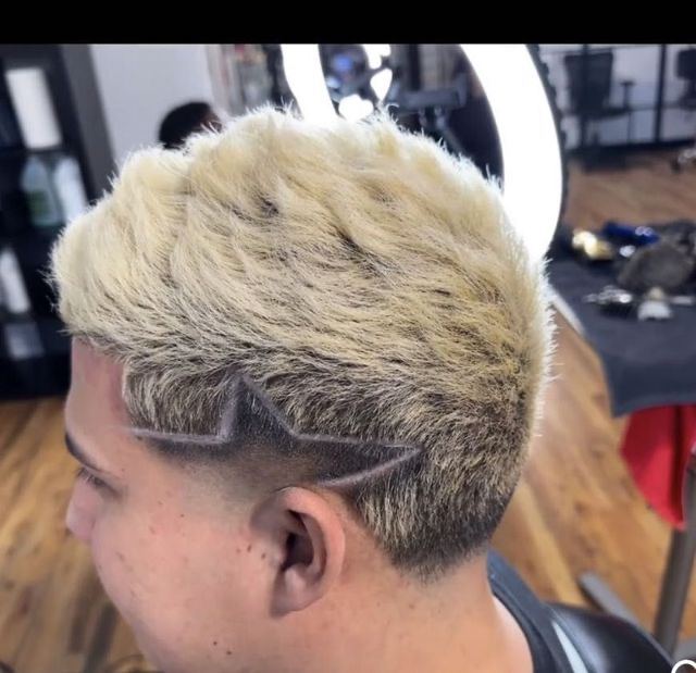 Blonde fade with a shaved star design at Masih.